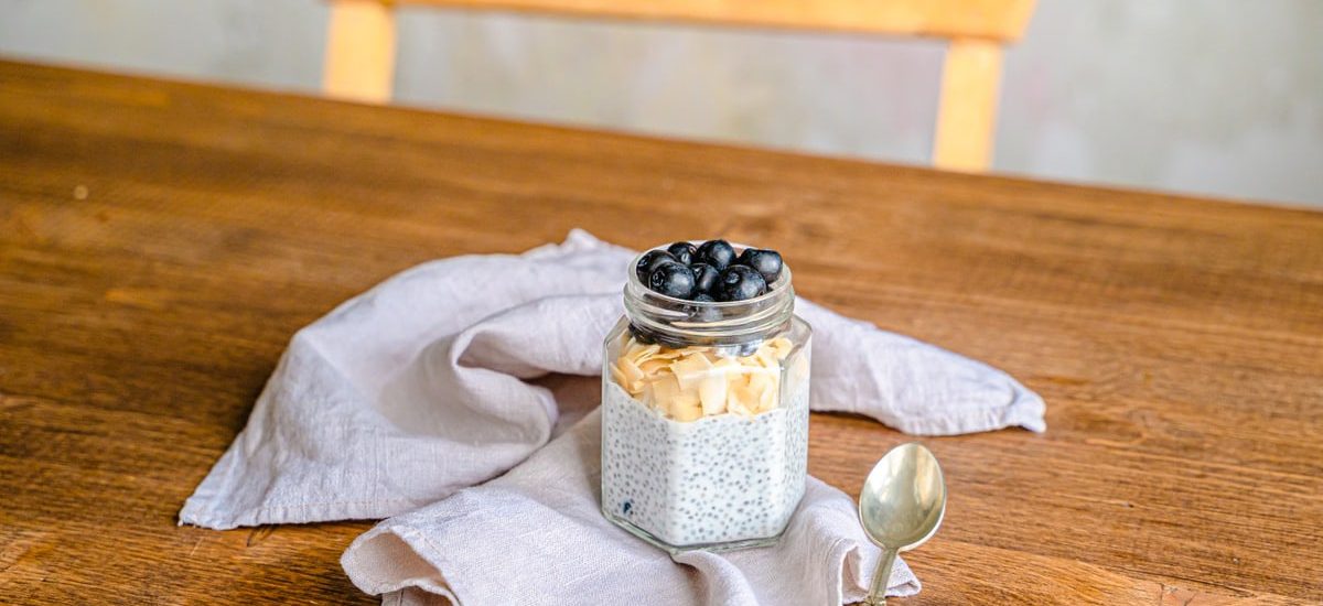 Healthy chia pudding with blueberries and coconut on a rustic wooden table. Perfect for breakfast.