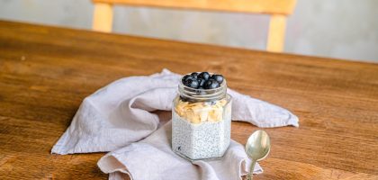 Healthy chia pudding with blueberries and coconut on a rustic wooden table. Perfect for breakfast.